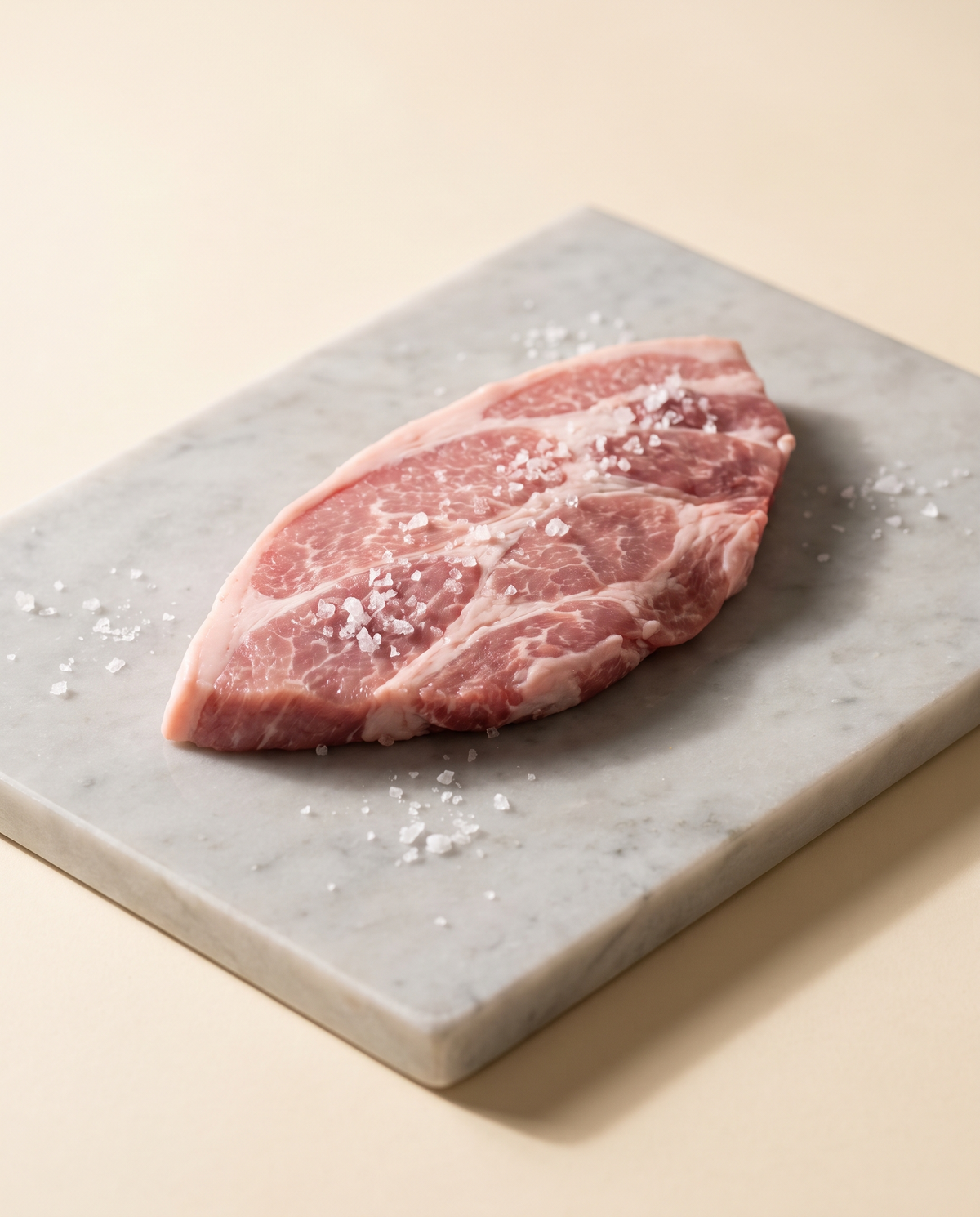 Secreto ibérico de cebo de campo crudo sobre mármol, con sal en escamas